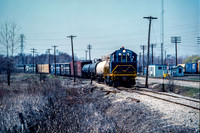 PH&D 60 pulls east with a GT train pulling west in the background, Michigan Road 4/1984.